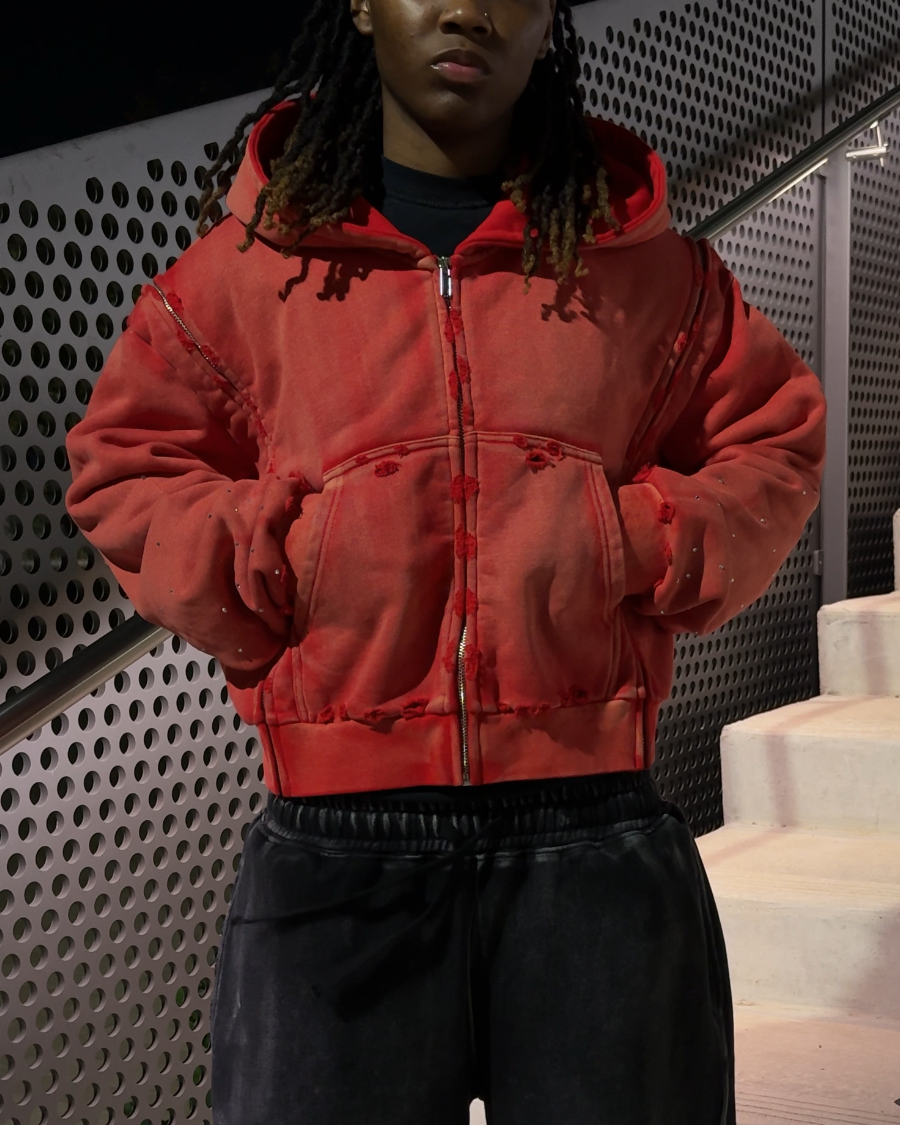 Model wearing the red interchangeable zip-up hoodie at night